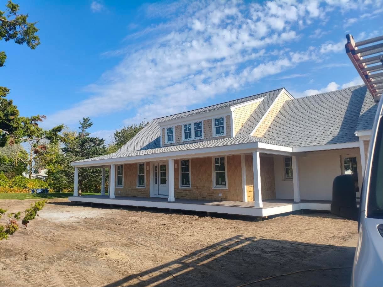 Open wood framing of a new house, rafters and trusses in place on a clear day